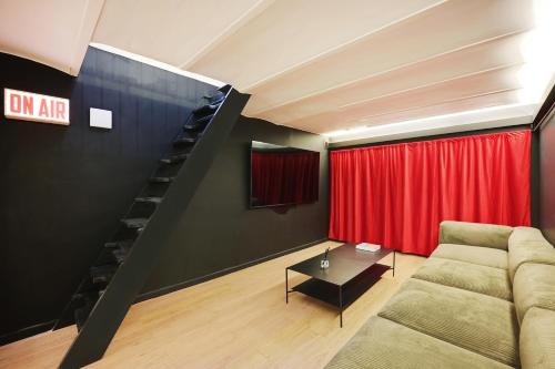 - un salon avec un canapé et un rideau rouge dans l'établissement Charming Flat, quartier latin with a private cinema, à Paris