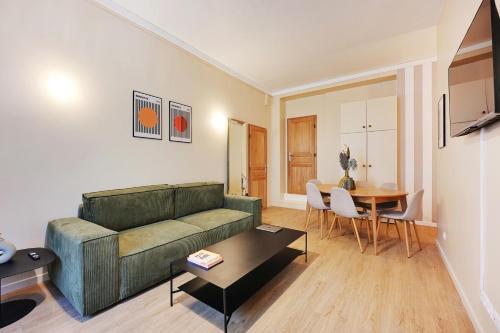un salon avec un canapé et une table dans l'établissement Charming Flat, quartier latin with a private cinema, à Paris
