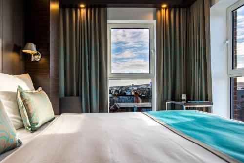 ein Schlafzimmer mit einem großen Bett und einem Fenster in der Unterkunft Motel One Newcastle in Newcastle upon Tyne