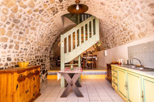 - une cuisine avec une table et un escalier dans une chambre dans l'établissement Gîtes du Domaine de Serre Long, à Saint-Maurice-dʼIbie