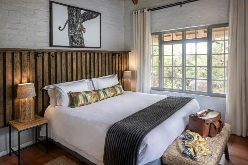um quarto com uma grande cama branca e janelas em Simbavati Mvubu Cottage em Timbavati Game Reserve