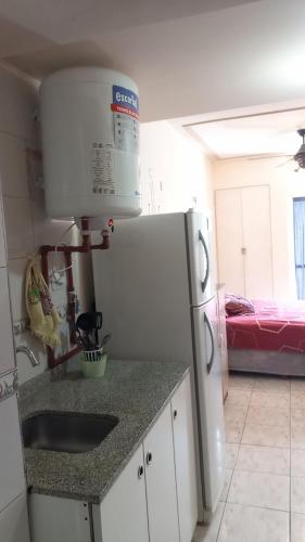 a kitchen with a white refrigerator and a bed at Alquiler temporal in San Miguel de Tucumán