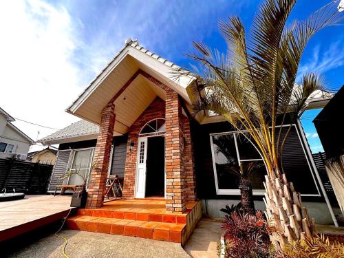 a house with a palm tree in front of it at The No.10 Sunrise Beach 九十九里 in Kujukuri