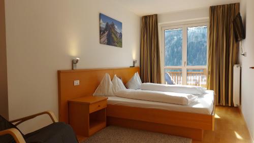 un dormitorio con una cama y una ventana en Salman, en Ortisei
