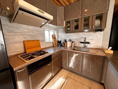 a small kitchen with a stove and a sink at The No.10 Sunrise Beach 九十九里 in Kujukuri