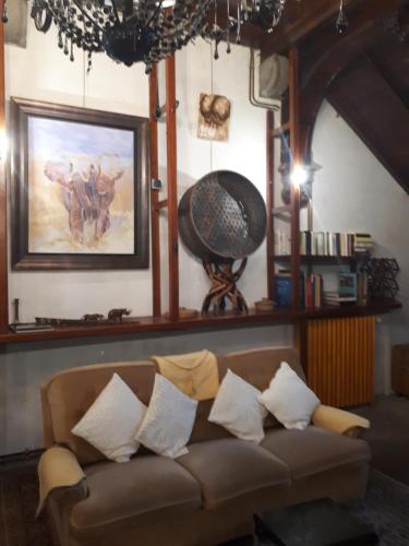 a living room with a brown couch with pillows at Loft atypique hyper centre à 5mn à pied de la plage de l'Écluse 2 à 8 personnes in Dinard