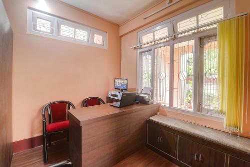 a home office with a desk and a window at Collection O Trinayan Associates in Dibrugarh