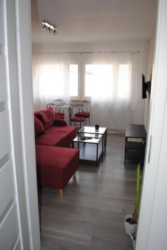 sala de estar con sofá rojo y mesa en Apartament Bukovska en Poznan