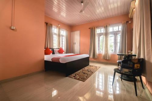 1 dormitorio con paredes de color naranja, 1 cama y ventanas en Collection O Trinayan Associates en Dibrugarh