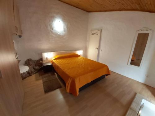 a bedroom with a bed with an orange blanket at Bela Vista House - Quinta amoreira in Benafim