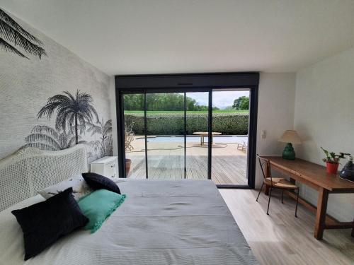 une chambre avec un lit, un bureau et une fenêtre dans l'établissement 4 pers / maison calme piscine / 15mn mythique circuit des 24h du Mans, au Mans