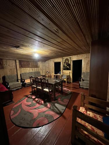 a living room with a table and chairs and a rug at Old House in Ushguli