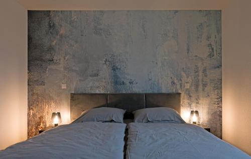 1 cama con 2 almohadas blancas y pared en Casa Lorsch 2, en Lorsch