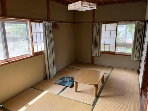 a room with a table and two windows at Ringoya in Hakuba