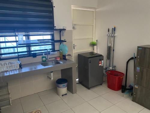 a kitchen with a sink and a refrigerator at Abu Fateh Homestay in Seri Iskandar