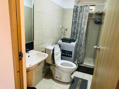 a small bathroom with a toilet and a sink at Shore Residence D23 shortwalk MOA in Manila