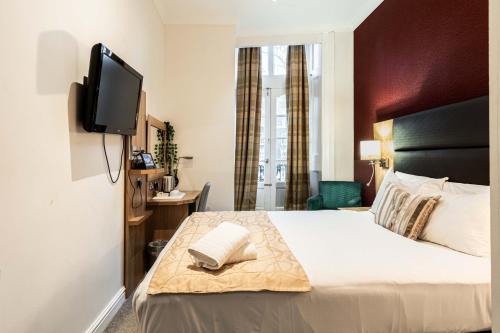 a hotel room with a bed with a flat screen tv at Lancaster Court Hotel in London