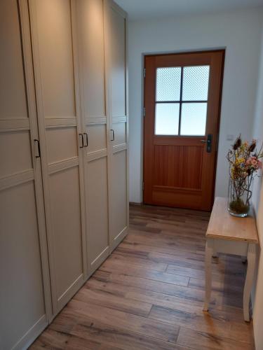 a room with a door and a table with a vase of flowers at MoarHof Feilnbach in Bad Feilnbach
