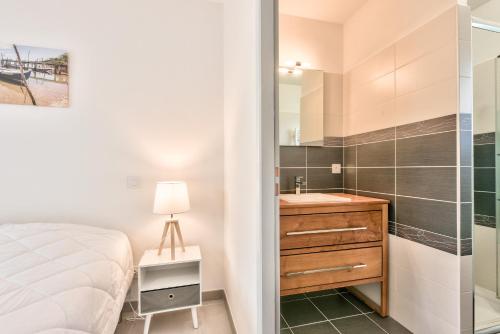 - une chambre avec un lit, un lavabo et une douche dans l'établissement Détente piscine à 150m de la plage à Arès, à Arès