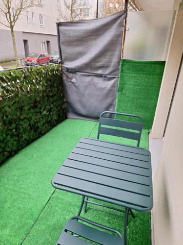 eine blaue Bank auf einem Balkon mit grünem Gras in der Unterkunft Nouveau - Quartier St Hélier in Rennes
