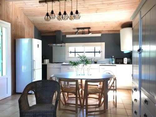 - une cuisine avec une table à manger et des chaises dans l'établissement LACANAU, à Lacanau