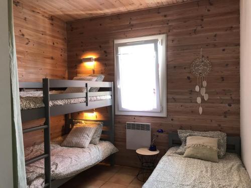 deux lits superposés dans une chambre avec fenêtre dans l'établissement LACANAU, à Lacanau
