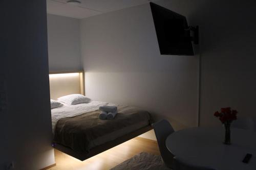 a small bedroom with a bed and a table at Modern Studio in Prime Location in Vantaa