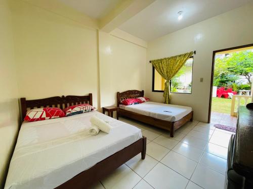 a bedroom with two beds and a window at LA FIESTA RESORT in Boracay