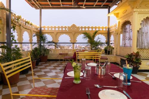a dining room with a table and chairs in a restaurant at Treebo The Fresco Lake Pichola in Udaipur
