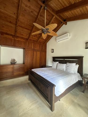 a bedroom with a large bed with a ceiling fan at Golf Views Near Bayahibe & Casa De Campo in La Romana