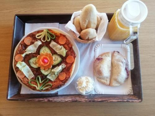 uma bandeja de comida com pizza e pão em Tarin zov em Kaludjerske Bare