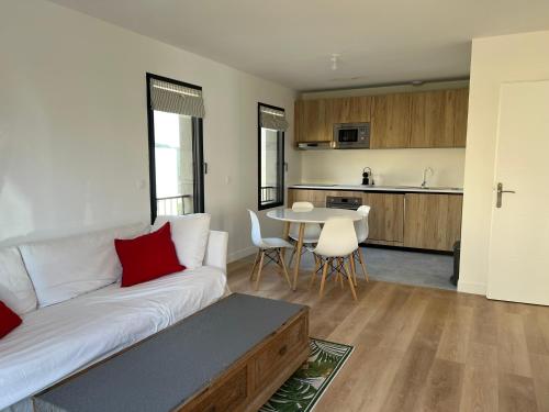 uma sala de estar com um sofá branco e uma cozinha em Bel appartement proche de cannes em Vallauris