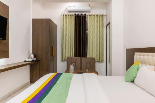 a bedroom with a bed and a table and chairs at Treebo The Fresco Lake Pichola in Udaipur