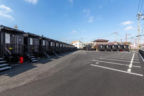 um parque de estacionamento vazio com uma fila de contentores em HOTEL R9 The Yard 荒尾 em Arao