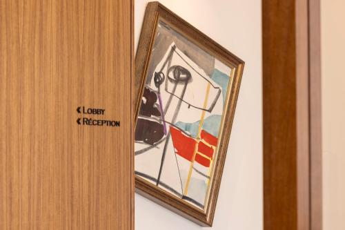 a painting of a dog hanging on a wall at Padam Hôtel in Paris