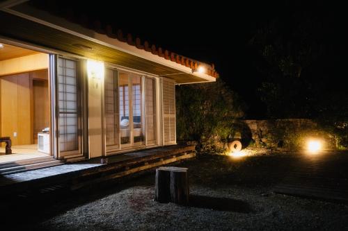 a house with a window at night with lights at totono house 満天の星空 テントサウナ BBQ 元有形文化財を1棟貸切 うるま市 浜比嘉島 in Uruma