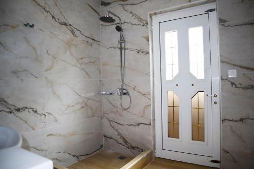 a bathroom with a shower and a white door at Villarosa Calma apartment in Stavros