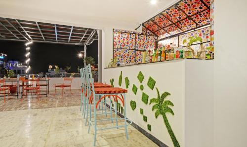 ein Restaurant mit Stühlen und Tischen und eine Wand mit Gemälden in der Unterkunft Treebo Trend The Fresco Lake Pichola in Udaipur