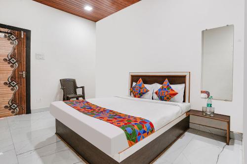 a bedroom with a bed and a chair in a room at Hotel Sai Lodging I - Nr Nashik Railway Station in Nashik