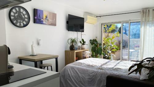 une chambre avec un lit et une horloge au mur dans l'établissement Studio clair, climatisé avec jardin et parking, à Perpignan