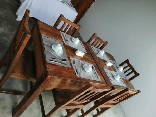 a wooden table with two chairs and a table with lights at Zangreen Bungalows in Jambiani
