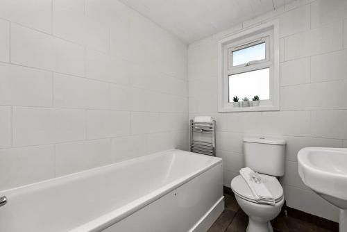 Spacious 1 bed flat close to Crouch End في لندن: حمام ابيض مع مرحاض ومغسلة