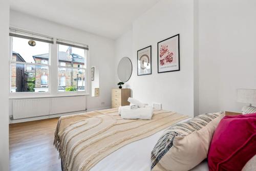 a white bedroom with a large bed and a mirror at Spacious 1 bed flat close to Crouch End in London