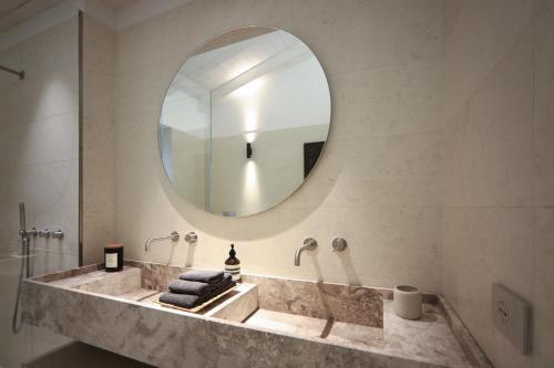 een badkamer met een grote spiegel en een wastafel bij Villa F in Bardolino