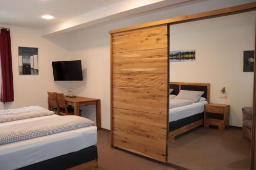 a bedroom with two beds and a large wooden cabinet at Landgasthof Post in Röthenbach