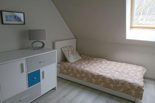 een kleine slaapkamer met een bed en een dressoir bij Gîte Les Pommiers in Montchaton