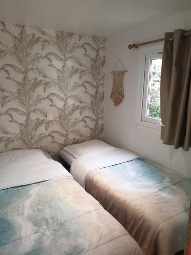 拉羅克當泰龍的住宿－Camping Domaine des Iscles，两张床位于带窗户的房间内