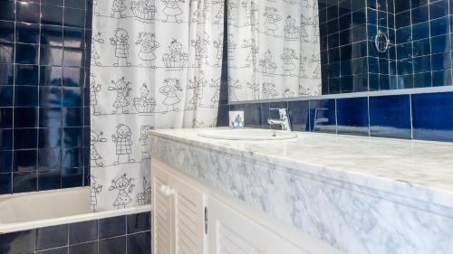 baño con lavabo y cortina de ducha en GERANIS en Llafranc