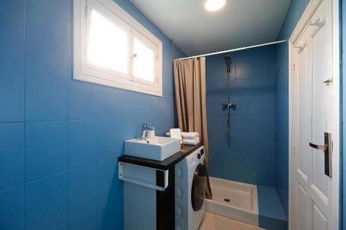 y baño azul con lavabo y ducha. en Apto. BLAIA en Irún