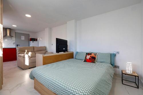 ein kleines Schlafzimmer mit einem Bett und einem Sofa in der Unterkunft Apto. BLAIA in Irún